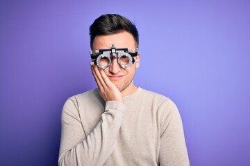 Young handsome caucasian man wearing optometrical glasses over purple background thinking looking tired and bored with depression problems with crossed arms.