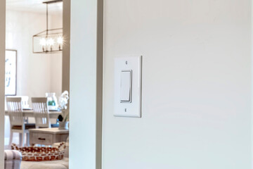 Wall mounted electrical rocker light switch with blurry dining room background