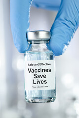 Healthcare concept with a hand in blue medical gloves holding vaccine vial with text Vaccines Save Lives