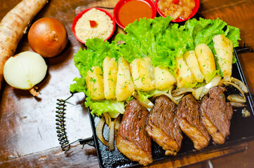 porção de picanha com mandioca