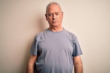 Middle age handsome hoary man wearing t-shirt standing over isolated white background with serious expression on face. Simple and natural looking at the camera.