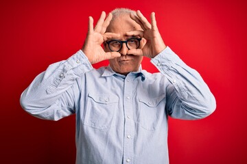 Middle age handsome hoary man wearing casual striped shirt and glasses over red background Trying to open eyes with fingers, sleepy and tired for morning fatigue