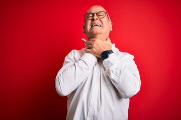 Middle age handsome hoary man wearing casual shirt and glasses over red background shouting suffocate because painful strangle. Health problem. Asphyxiate and suicide concept.