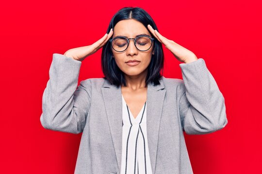 Young beautiful latin woman wearing business clothes with hand on head, headache because stress. suffering migraine.