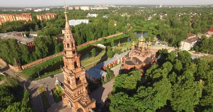 4K aerial summer morning high quality video footage of red brick Gefsimanskiy skit grand cathedral church with golden cupolas in small vintage town Sergiev Posad in Moscow Oblast in central Russia