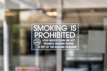 Clear glass entrance door of a building in Utah with Smoking Is Prohibited sign