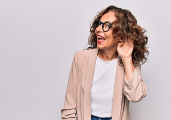 Middle age beautiful businesswoman wearing glasses standing over isolated white background smiling...