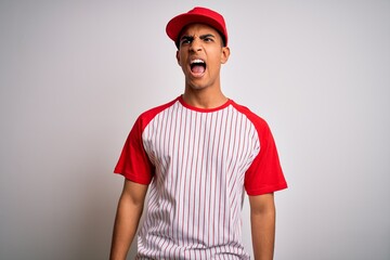 Young handsome african american sportsman wearing striped baseball t-shirt and cap angry and mad screaming frustrated and furious, shouting with anger. Rage and aggressive concept.