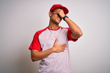Young handsome african american sportsman wearing striped baseball t-shirt and cap Touching...