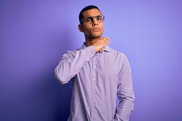 Handsome african american man wearing striped shirt and glasses over purple background cutting throat with hand as knife, threaten aggression with furious violence