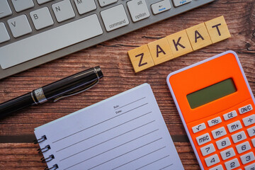 ZAKAT (islamic tax) text on wooden table. Islamic zakat concept. Selective focus.