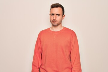 Fototapeta premium Young handsome man with blue eyes wearing casual sweater standing over white background skeptic and nervous, frowning upset because of problem. Negative person.