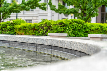 Outdoor circular stone pool against trees and Utah State Capital Building