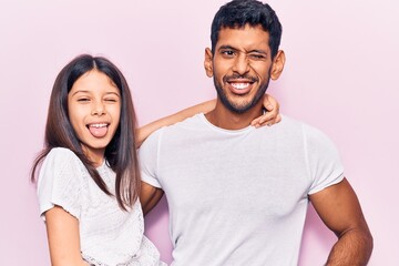 Latin father and daughter wearing casual clothes smiling positive doing ok sign with hand and fingers. successful expression.