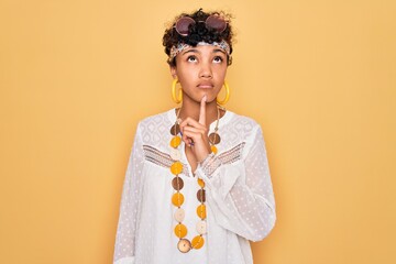 Young beautiful african american afro hippie woman wearing sunglasses and accessories Thinking...