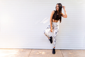 Attractive female athlete posing in sporty clothes and yoga pants 