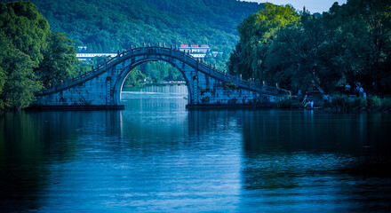 There is a bridge in the middle of the calm lake