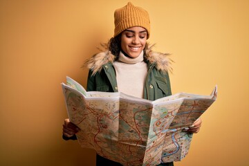 African american skier tourist girl wearing snow sportswear and ski goggles holding city map with a...