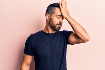 Young hispanic man wearing casual clothes surprised with hand on head for mistake, remember error....