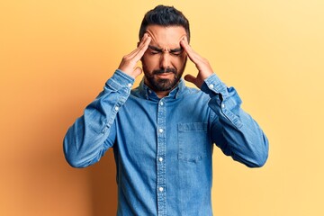 Obraz premium Young hispanic man wearing casual clothes with hand on head for pain in head because stress. suffering migraine.