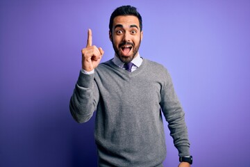 Fototapeta premium Handsome businessman with beard wearing casual tie standing over purple background pointing finger up with successful idea. Exited and happy. Number one.