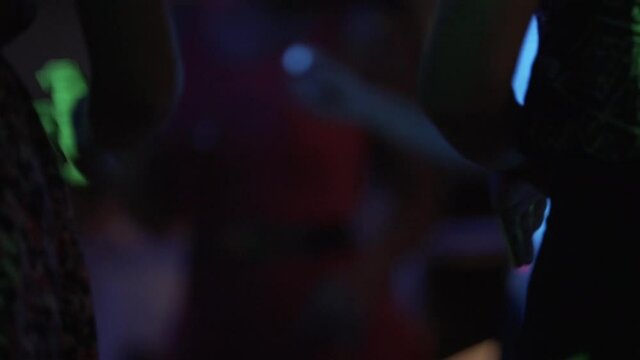 extreme close up of low part of women body dancing at a party in a nightclub , party lights amazing lifestyle