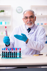 Old male chemist working in the lab