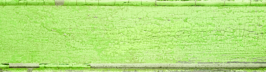 Cracked and peeling bright lime green paint on wood with texture and grunge finish
