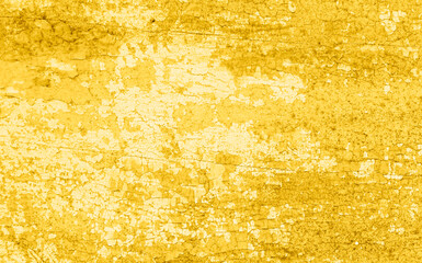 Cracked and peeling yellow gold paint on wood with texture and grunge finish
