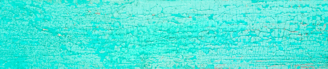 Old crackled teal turquoise painted wood surface. Vintage wooden wall or floor with cracked paint.