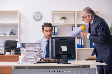 Old boss and young male employee in the office