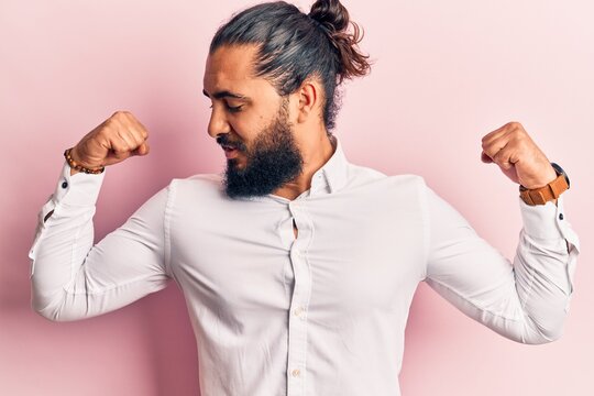 Young arab man wearing casual clothes showing arms muscles smiling proud. fitness concept.