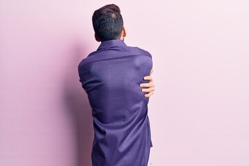 Young handsome man with beard wearing casual shirt hugging oneself happy and positive from...
