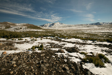 Fototapeta na wymiar Panorama view of the rocky ground, meadow and snowy mountains.