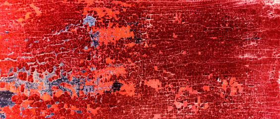 Cracked and peeling red oxidized paint on wood with texture and grunge finish
