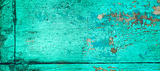 Old crackled teal turquoise painted wood surface. Vintage wooden wall or floor with cracked paint.