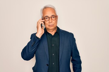 Middle age senior grey-haired business man wearing glasses talking on smartphone with a confident...