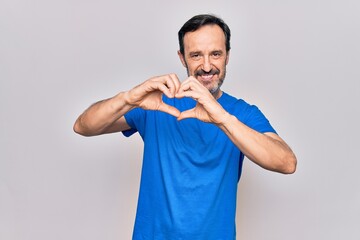 Middle age handsome man wearing casual t-shirt standing over isolated white background smiling in love doing heart symbol shape with hands. Romantic concept.