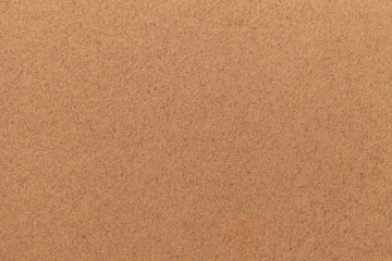 Texture of old light brown paper. Structure of a matte dense cardboard wallpaper. Sand felt background.