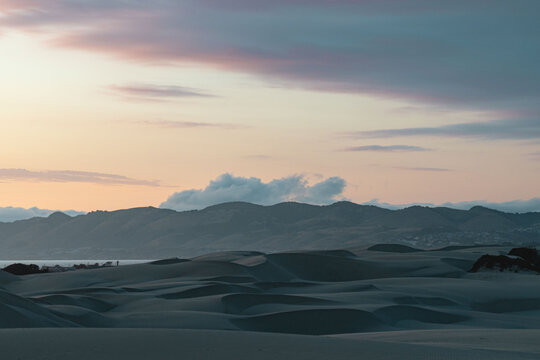 View of sand dunes against cloudy sky