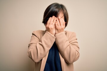 Young down syndrome business woman wearing glasses standing over isolated background with sad...