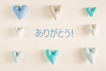 Arigato - Thank you in Japanese language with blue heart cushions on a white paper background