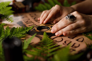 Mystic ritual with Ouija and candles. Devil's board concept, black magic or fortune telling rite...