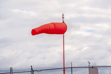 Red wind sock at an airport blowing in the wind