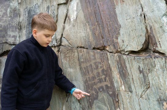 Ancient cave paintings and little boy. Bronze Age culture dated to the first half of the 2nd millennium BC.	