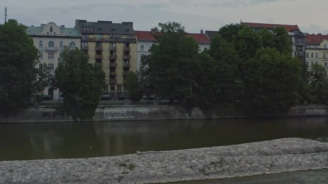 Stabilized rise up of a drone from the Isar river up to the roofs of Munich within the popular Frauenkirche.