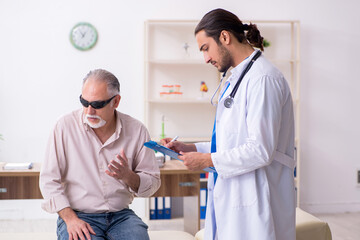 Fototapeta premium Old blind man visiting young male doctor