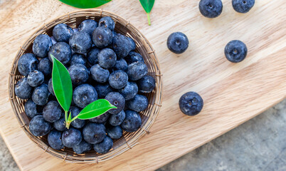 Blueberries in the basket on wooden board, Top view