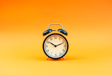 Alarm clock on an orange background.