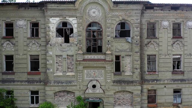 Abandoned palace or manor (mansion) house in the neoclassical style with an abundance of decor and broken windows. Deserted old building of the 19th century. Aerial side view